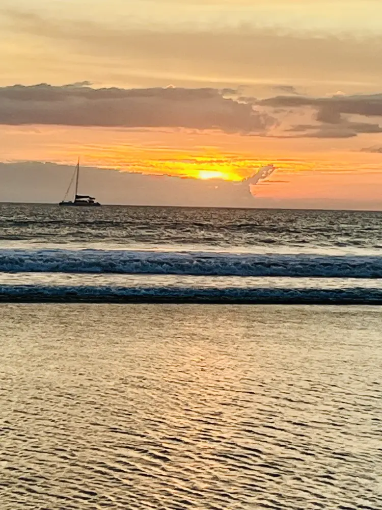 Catamaran sailing past Playa Grande at sunset