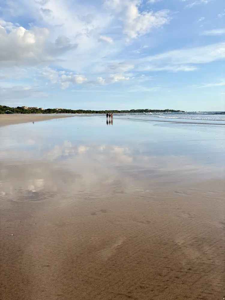 A couple walking on the blue-sky mirror