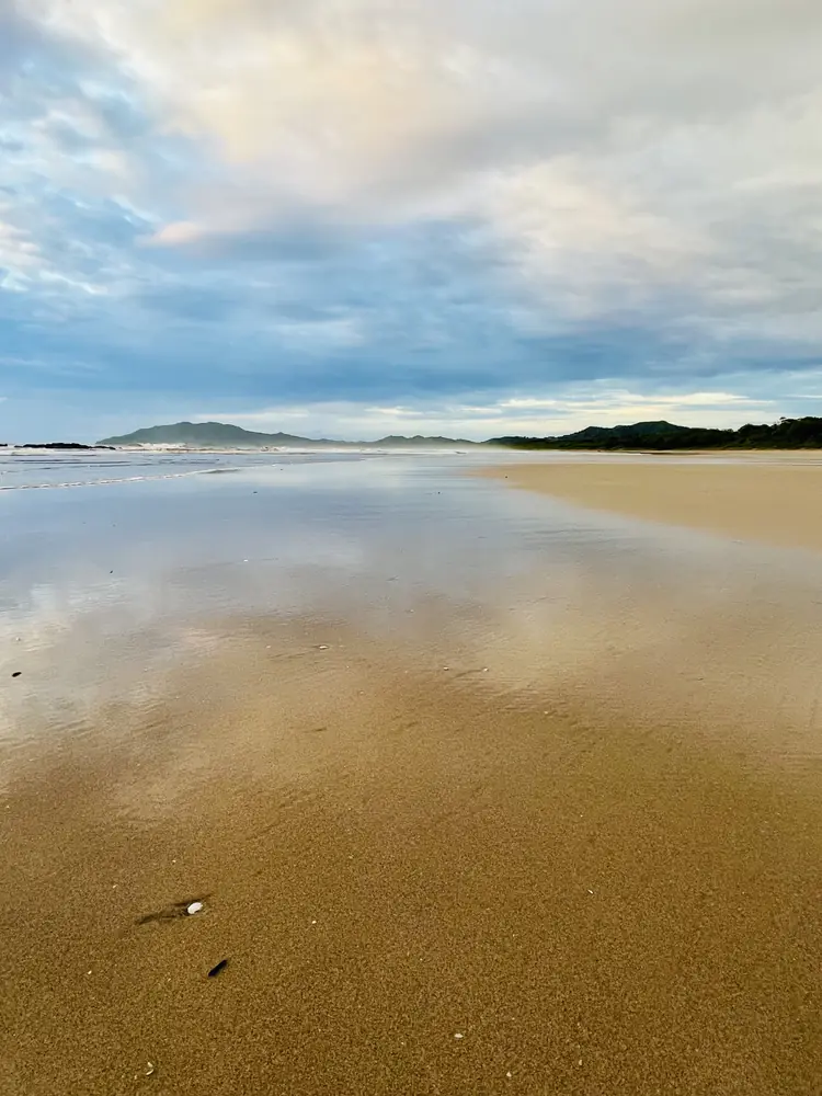 A soft sky on glassy sand