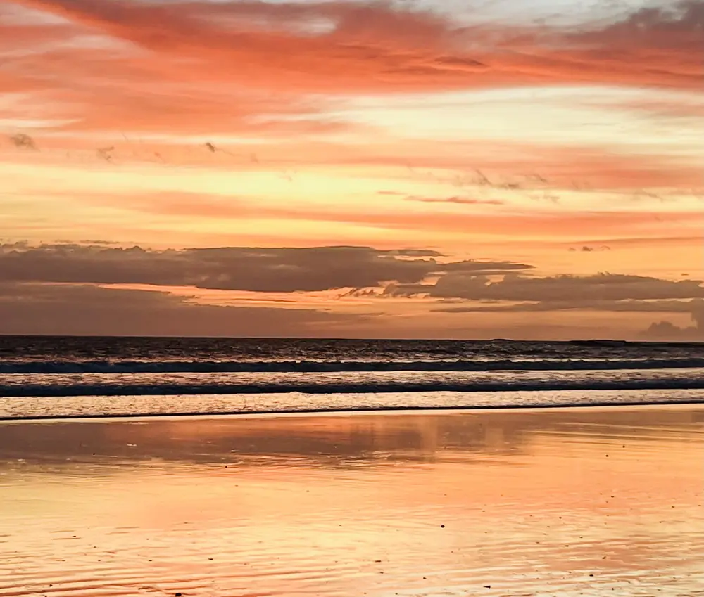 Streaks of pink and orange over the surf