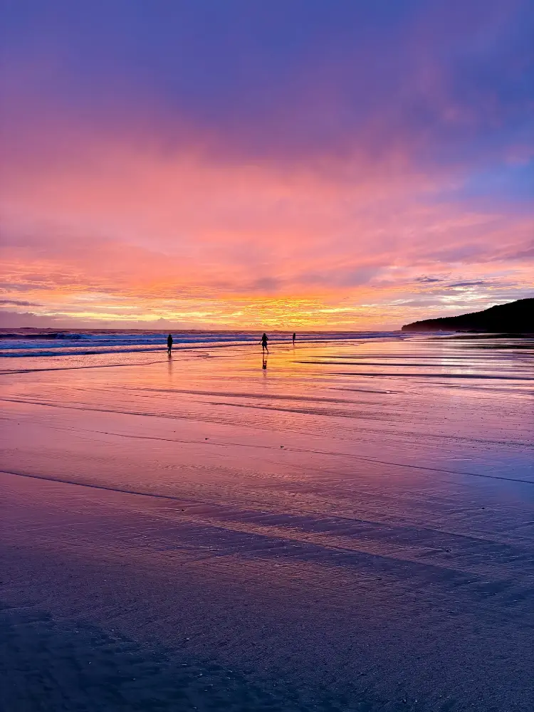 Pink sky over the wet sand at low tide