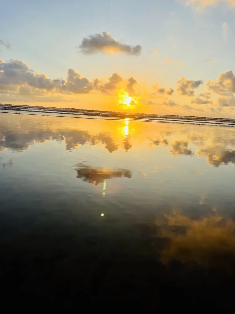 A column of sunlight on the wet sand