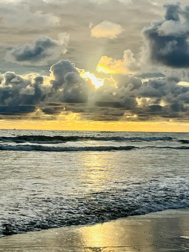 The sun breaking through over the surf