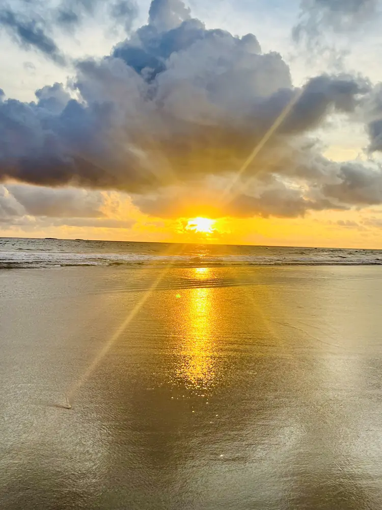A sunburst under a towering cloud