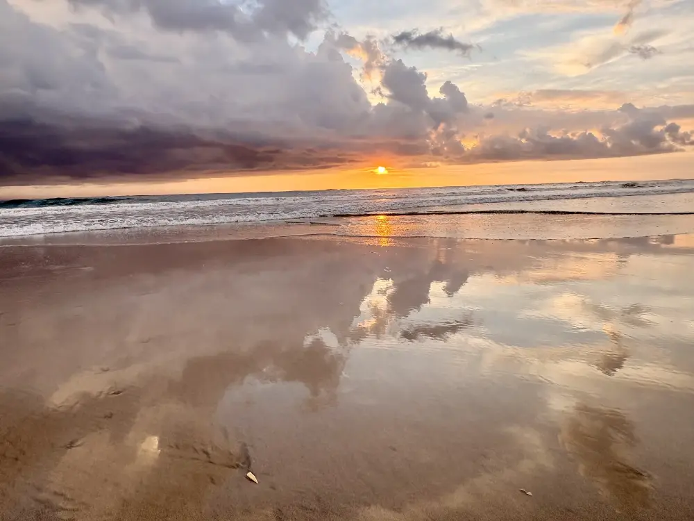Clouds mirrored in the wet sand